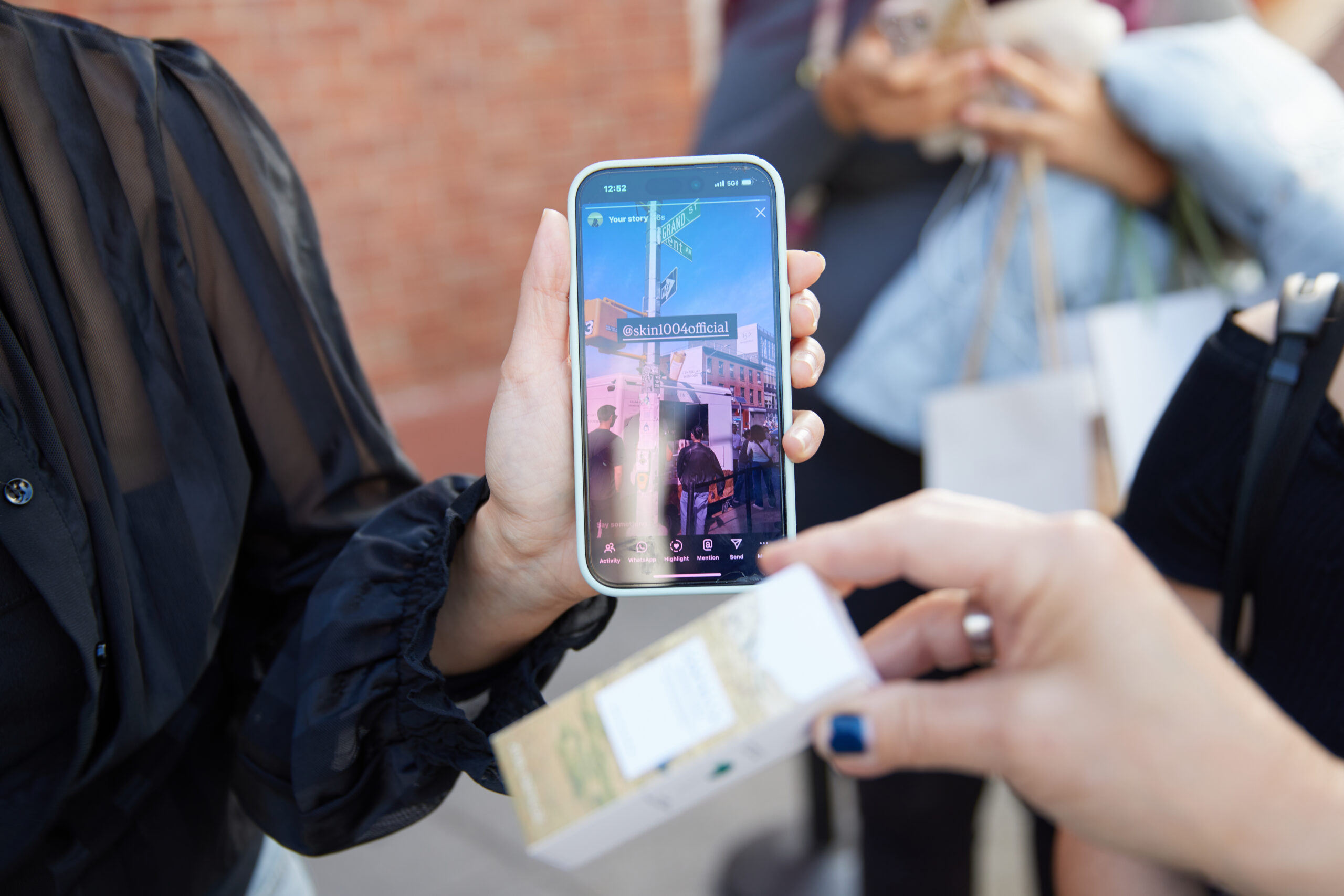 Guest using a phone to photograph or scan a product at the SKIN1004 pop-up activation.