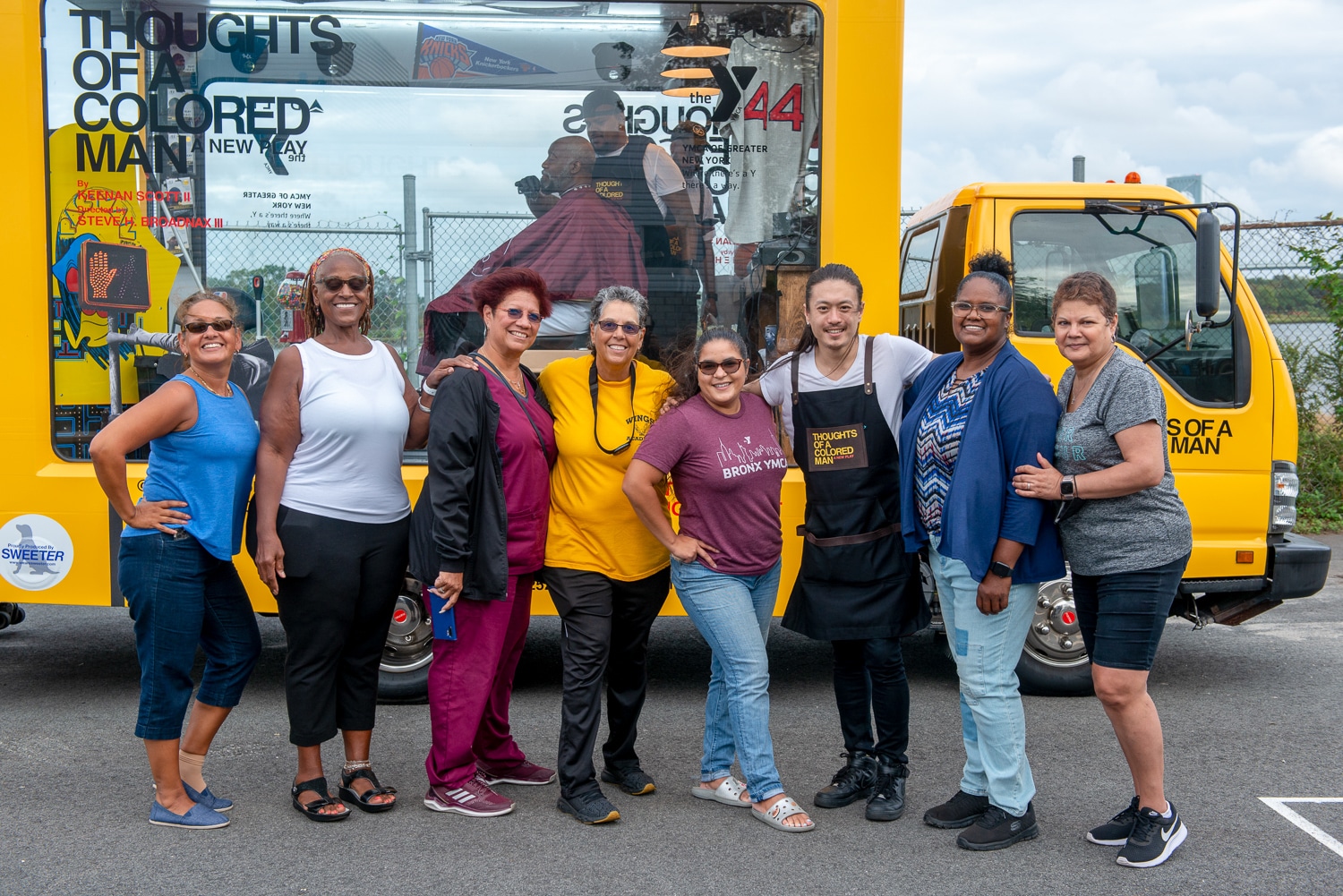 Activation team posing in front of a colorful mobile barbershop truck.