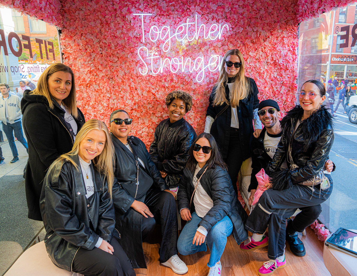 Activation team posing in front of a colorful Together Stronger event backdrop.