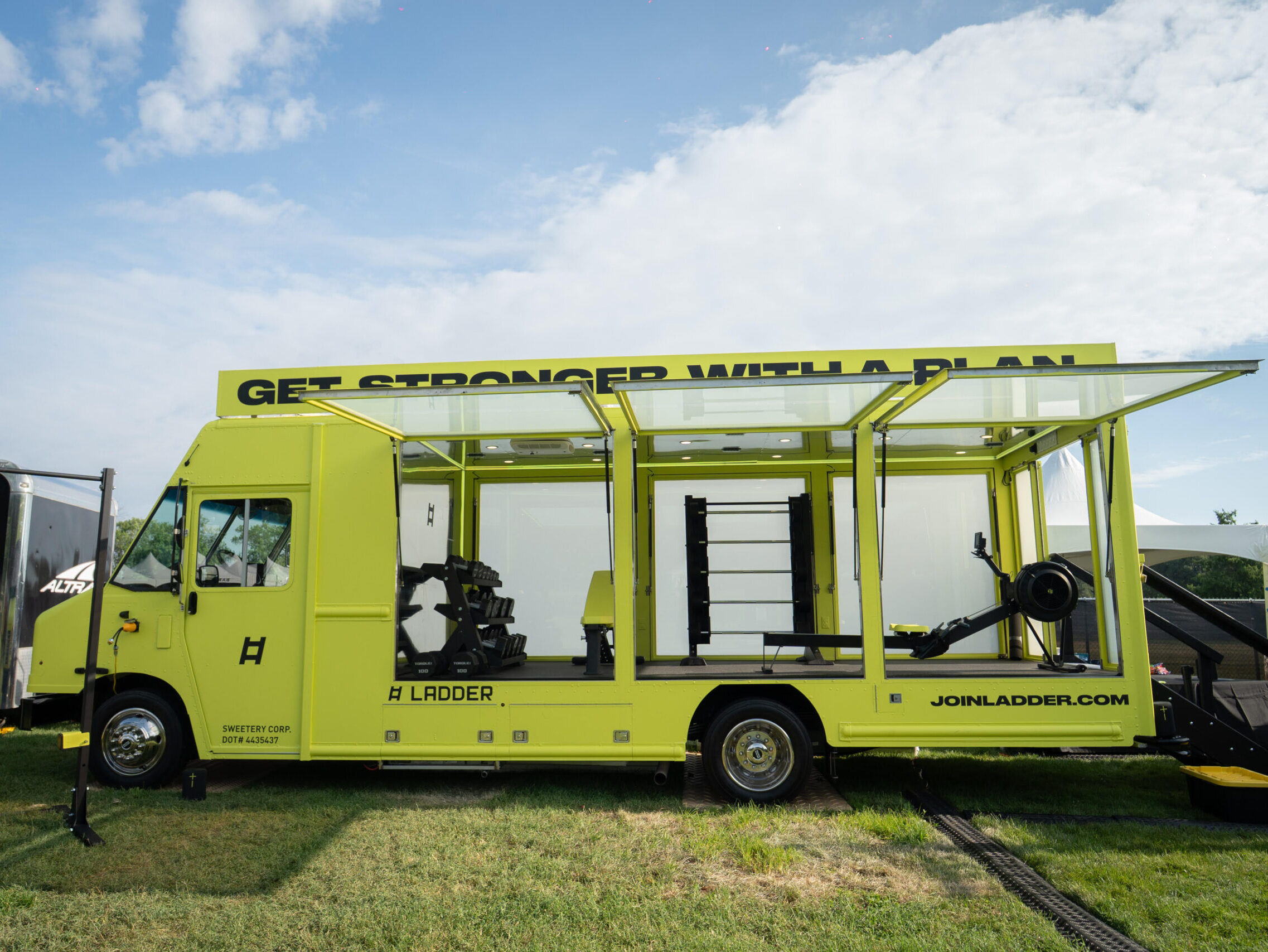 Custom glass box truck used for experiential marketing featuring a branded fitness activation with an open display for consumer engagement and mobile brand activation.