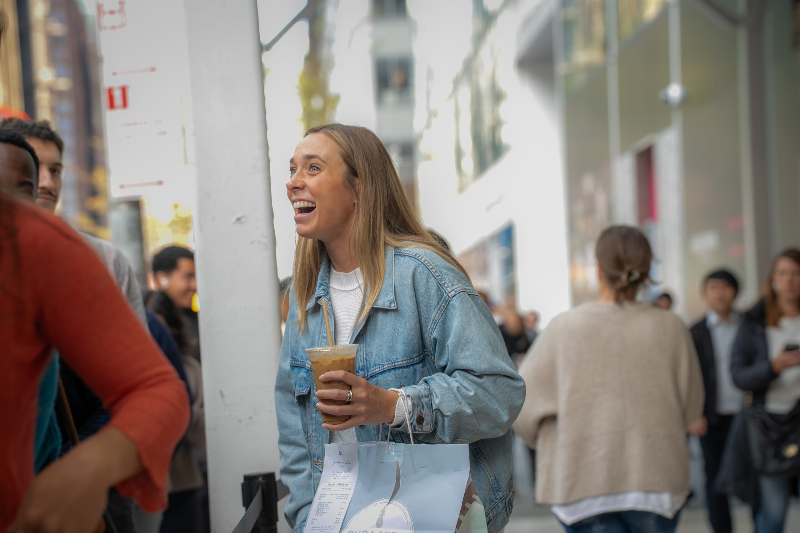 Guest smiling with a beverage during an indoor experiential marketing event.