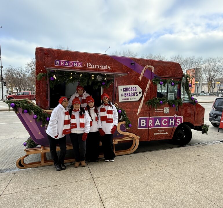 Brach’s holiday branded food truck with brand ambassadors posing in front of the mobile candy sampling activation.