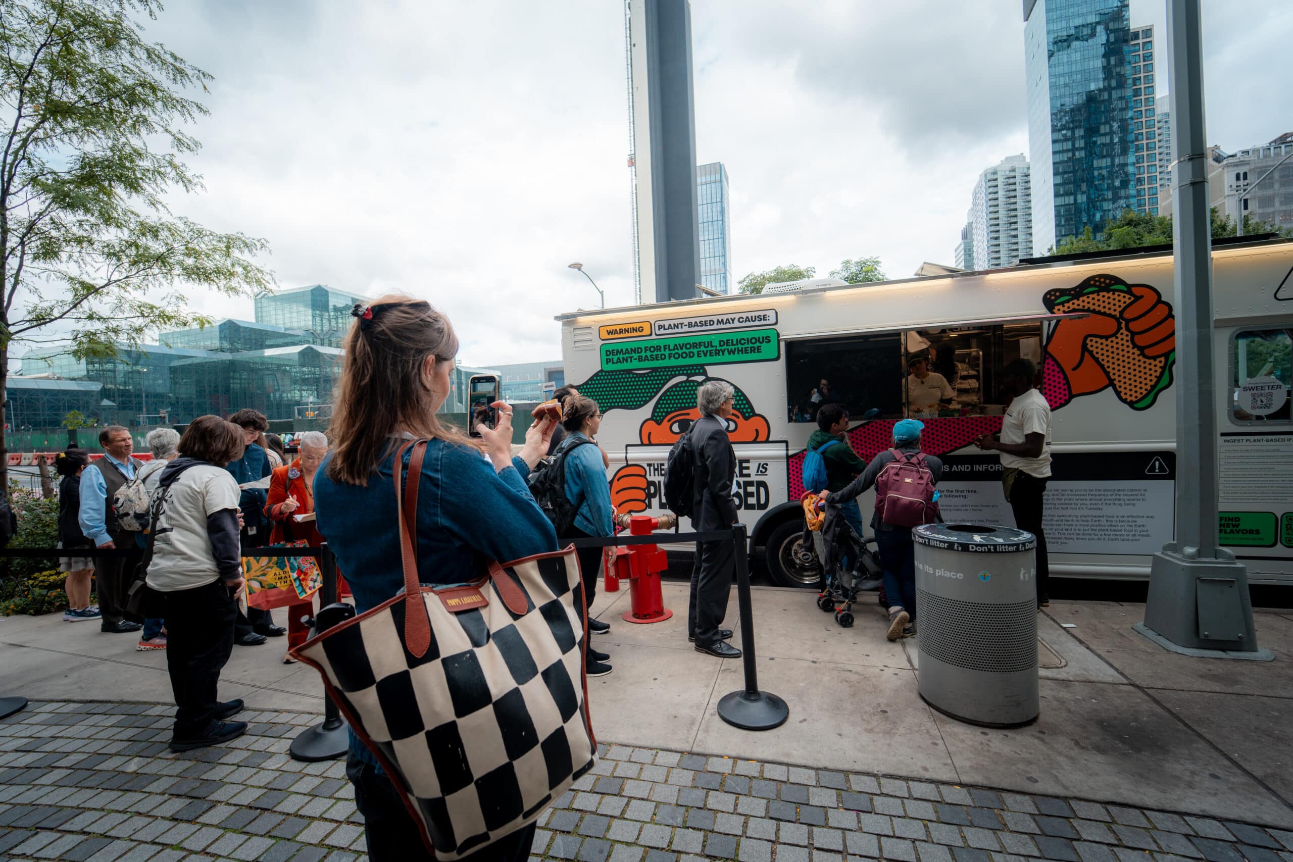 Crowd gathering beside a Grow Plant Based branded food truck during a plant-based food sampling activation.