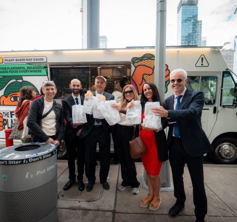Grow Plant Based branded food truck with guests holding sample bags in front of the plant-based food activation.