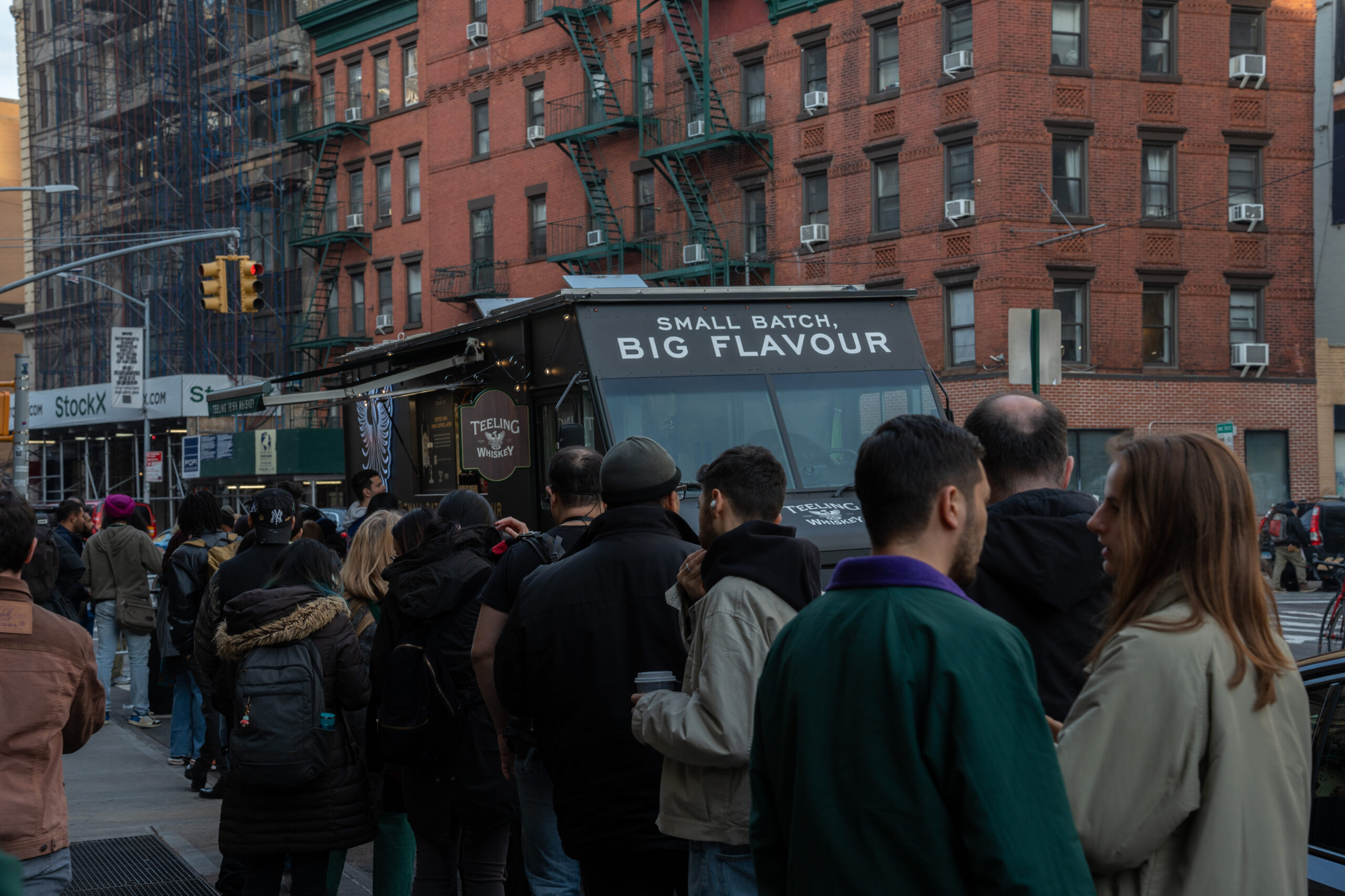 Crowd gathered outside a dark branded mobile food activation in the city.